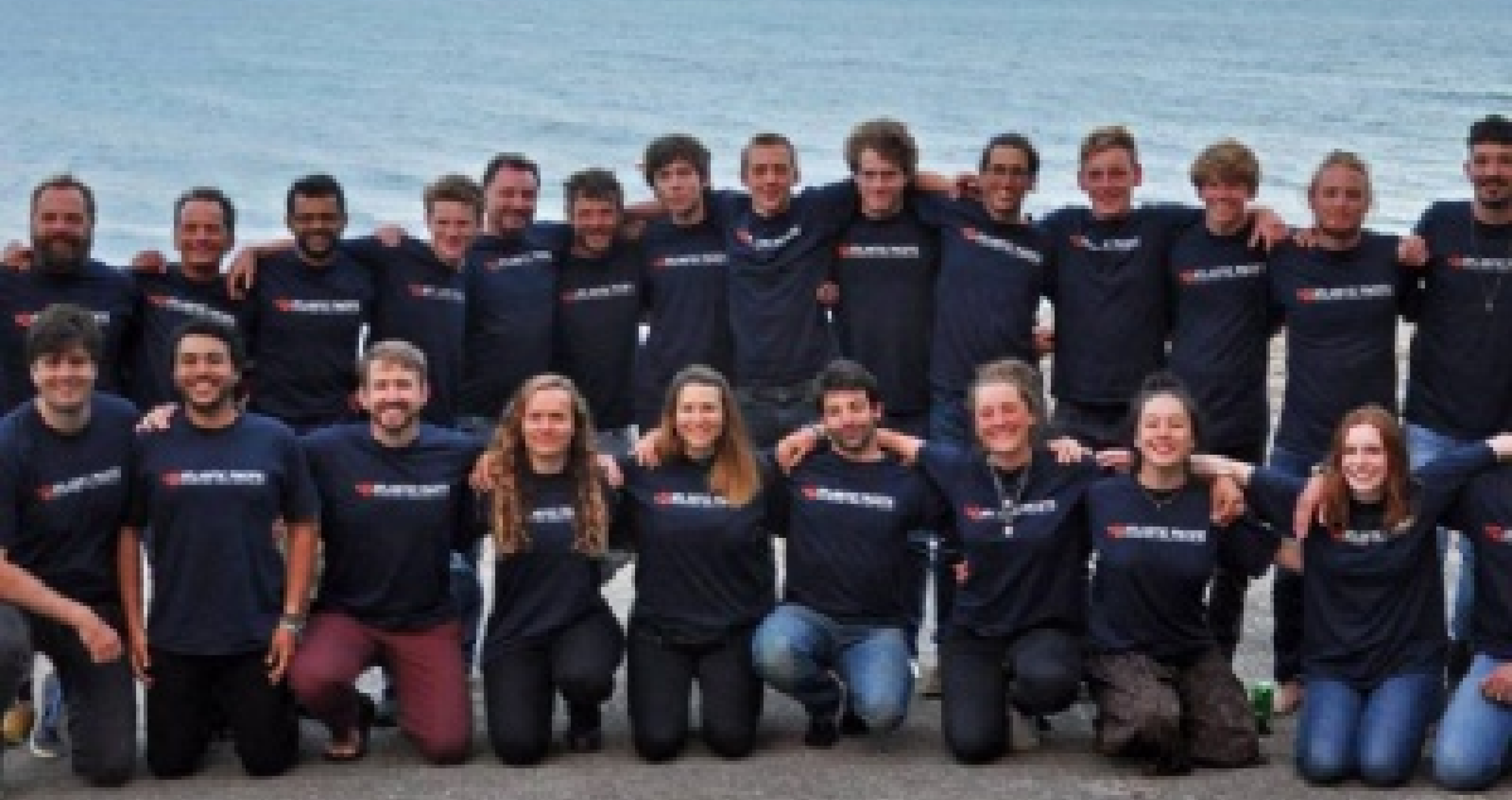 Men and Women holding each other, posing for picture